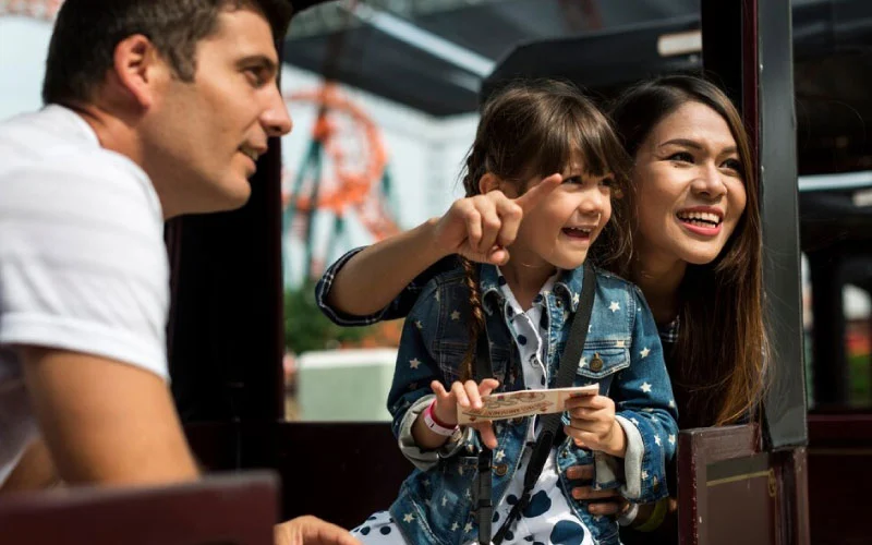 A happy family boarding a coach headed to Alton Towers Resort, ready for a thrilling theme park adventure.