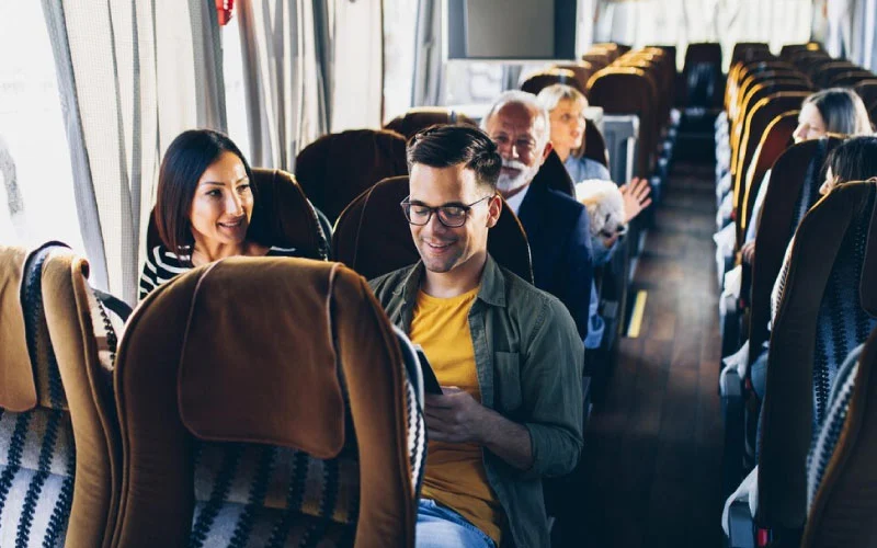 A luxury tour bus parked near a historic UK landmark, ready for group travel.