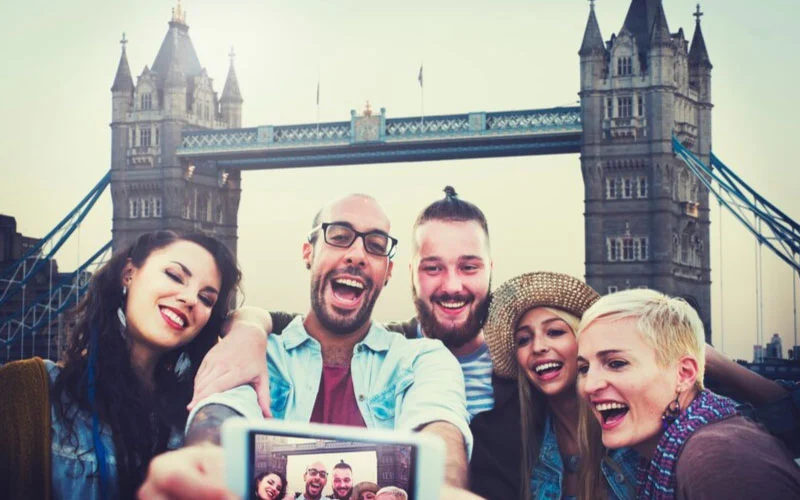 Happy tourists enjoying a scenic bus ride in London with The London Coach Company.